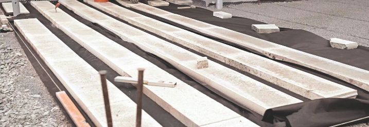 Als Unterbau für eine Holzterrasse werden vier Bahnen Betonplatten verlegt.
